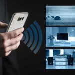 Smartphone controlando automação residencial, com painéis de segurança e iluminação.